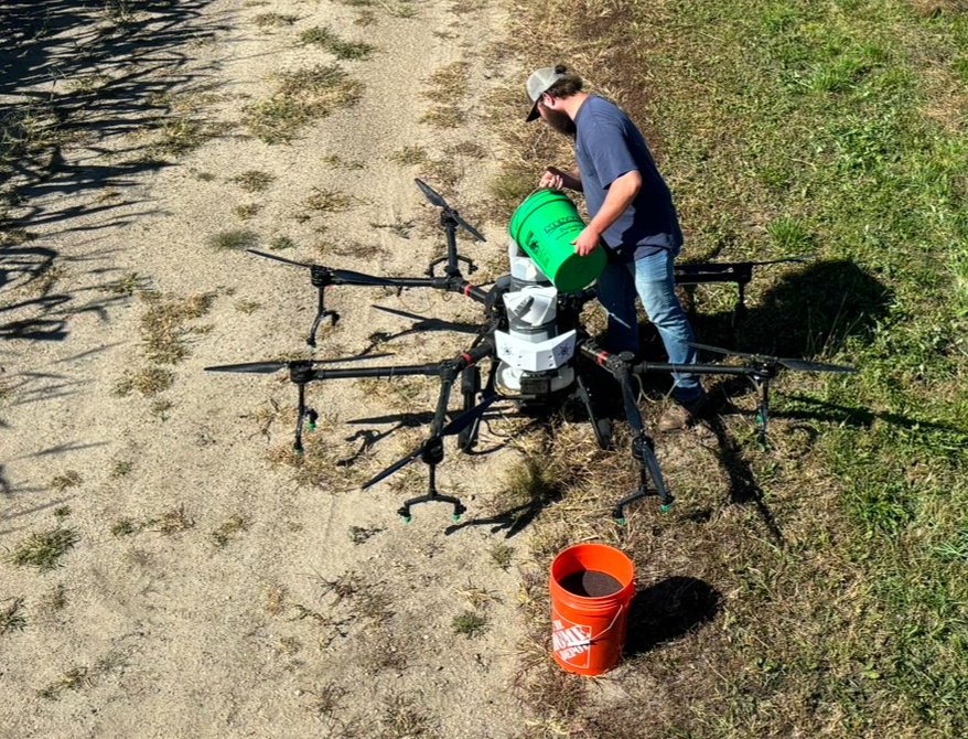 Drone applicator loading the drone with the precise seed weight.